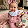 Bonnie is registered to the contest to win money with this photo: baby, pink_clothing, headband, bow, smiling, toy, fabric_cube, blanket, indoor, soft_toys, child, cute, playtime, happy, portrait, infant, home, floor_mat, sitting, cozy