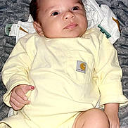 Sebastian joined the competition — help win amazing prizes! baby, infant, onesie, yellow_clothing, blanket, gray_blanket, skin, face, legs, hand, lying_down, indoors, cute, newborn, child, portrait, soft_texture, comfort, clothing_label, expression