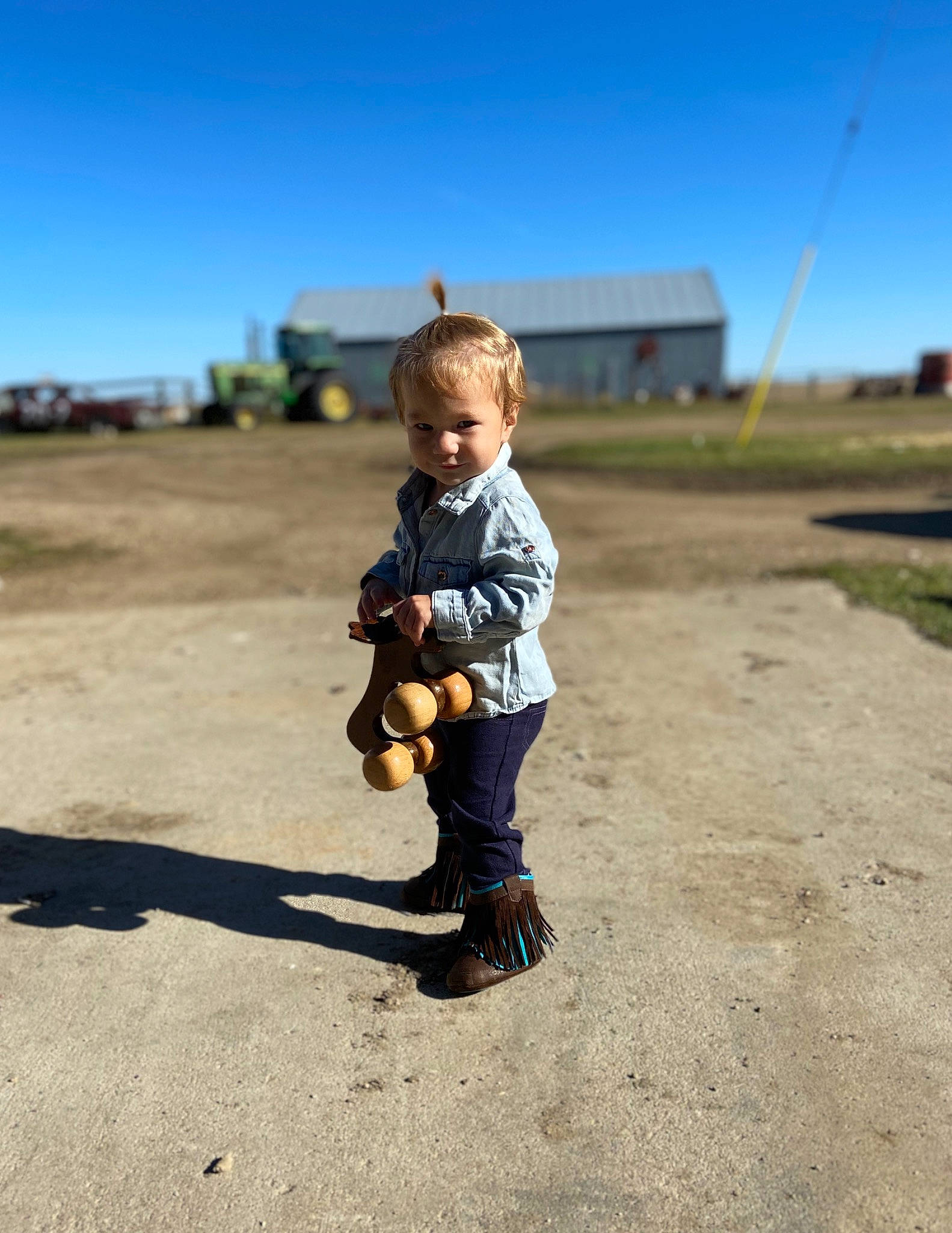 Abbygail is registered to the contest to win money with this photo: asphalt, baby, body_of_water, boot, fun, grass, grassland, happy, landscape, leisure, people_in_nature, person, recreation, road_surface, sand, shadow, sitting, sky, sneakers, soil