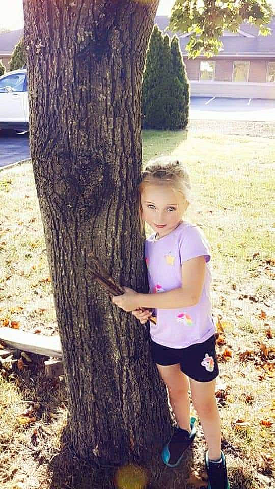 Violet is registered to the contest to win money with this photo: grass, green, happy, human_body, joy, knee, leg, leisure, people_in_nature, person, photograph, plant, shorts, snapshot, summer, thigh, tree, trunk, waist, wood