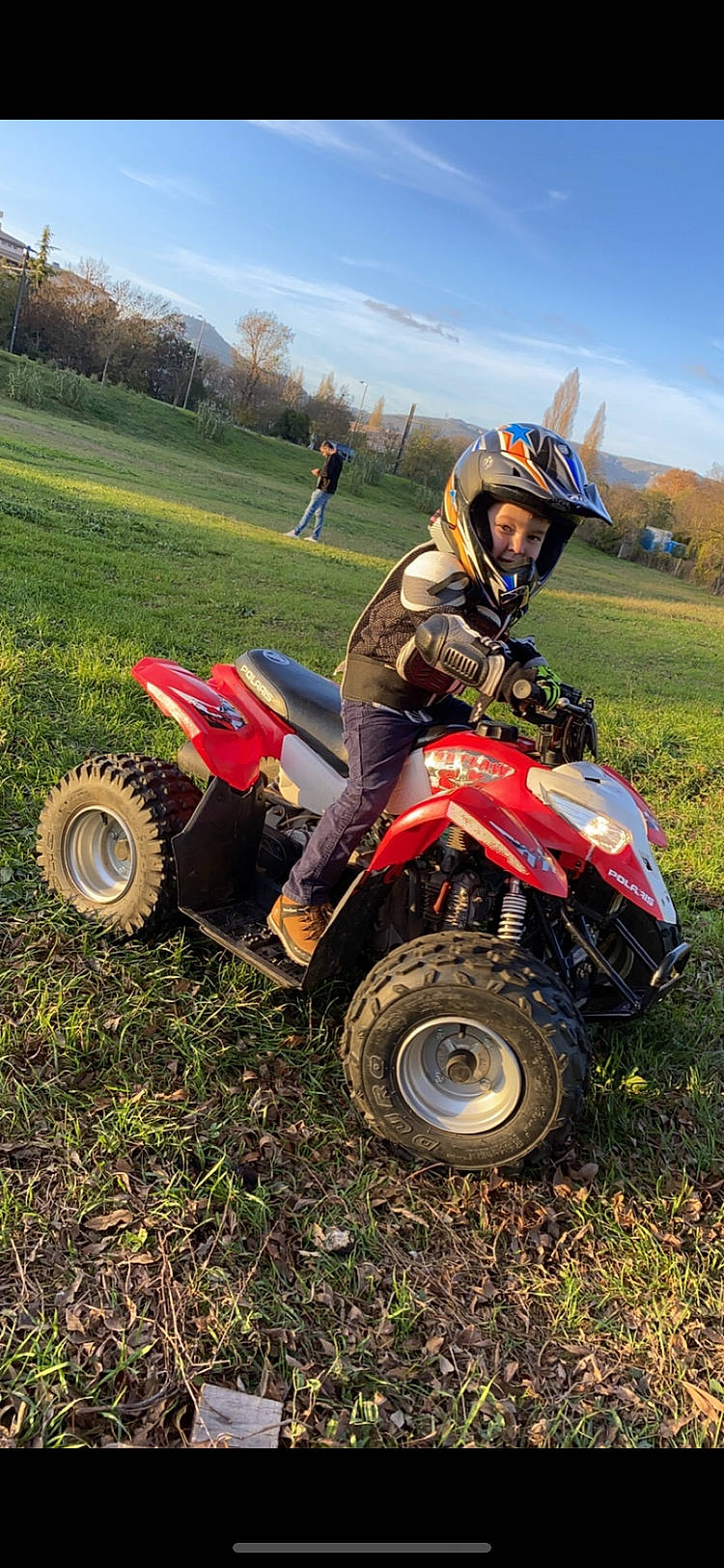 Ange participe au concours pour gagner de l'argent avec cette photo : automotive_design, automotive_tire, automotive_wheel_system, cloud, fender, grass, grassland, headwear, helmet, jacket, land_vehicle, landscape, motor_vehicle, person, plain, plant, sky, tire, tread, tree