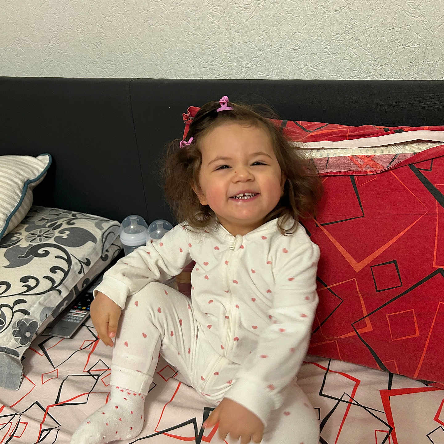 Madlen Lazarova a rejoint le concours — aidez-le/la à gagner de superbes lots ! toddler, child, smiling, pajamas, hair_clips, bed, pillow, baby_bottle, indoor, patterned_bedspread, white_clothing, happy, cute, sitting, person, cozy, home, young_child, playful, casual