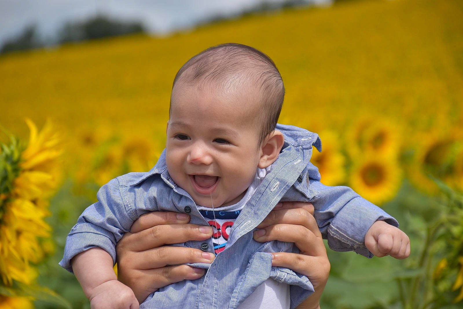 Eddy a rejoint le concours — aidez-le/la à gagner de superbes lots ! agriculture, baby, baby_toddler_clothing, flower, fun, gesture, grass, grass_family, grassland, hand, happy, iris, meadow, people_in_nature, person, plant, skin, smile, thumb, toddler