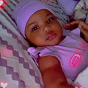 Kehlani is registered to the contest to win money with this photo: baby, baby_outfit, bed, bedding, bedroom, blanket, cap, child, digital_filter, eyes, face, hat, heart_effects, indoor, infant, looking_at_camera, lying_down, photography, portrait, purple_clothing