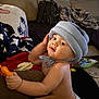 Remington joined the competition — help win amazing prizes! baby, blanket, child, comfort, couch, cute, diaper, expression, face, furniture, hat, home, indoor, infant, living_room, person, play, plush, soft_lighting, toy