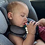 arm, baby, beads, car_seat, child, close_up, clothing, hand, head, indoor, infant, peaceful, portrait, relaxation, seat_belt, skin, sleeping, thumb_in_mouth, toy, window