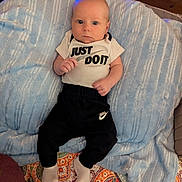 Oaklee joined the competition — help win amazing prizes! baby, infant, blanket, clothing, pants, socks, face, person, indoor, bed, patterned_quilt, wooden_wall, blue_blanket, nike, onesie, footwear, cute, young_child, portrait, lying_down