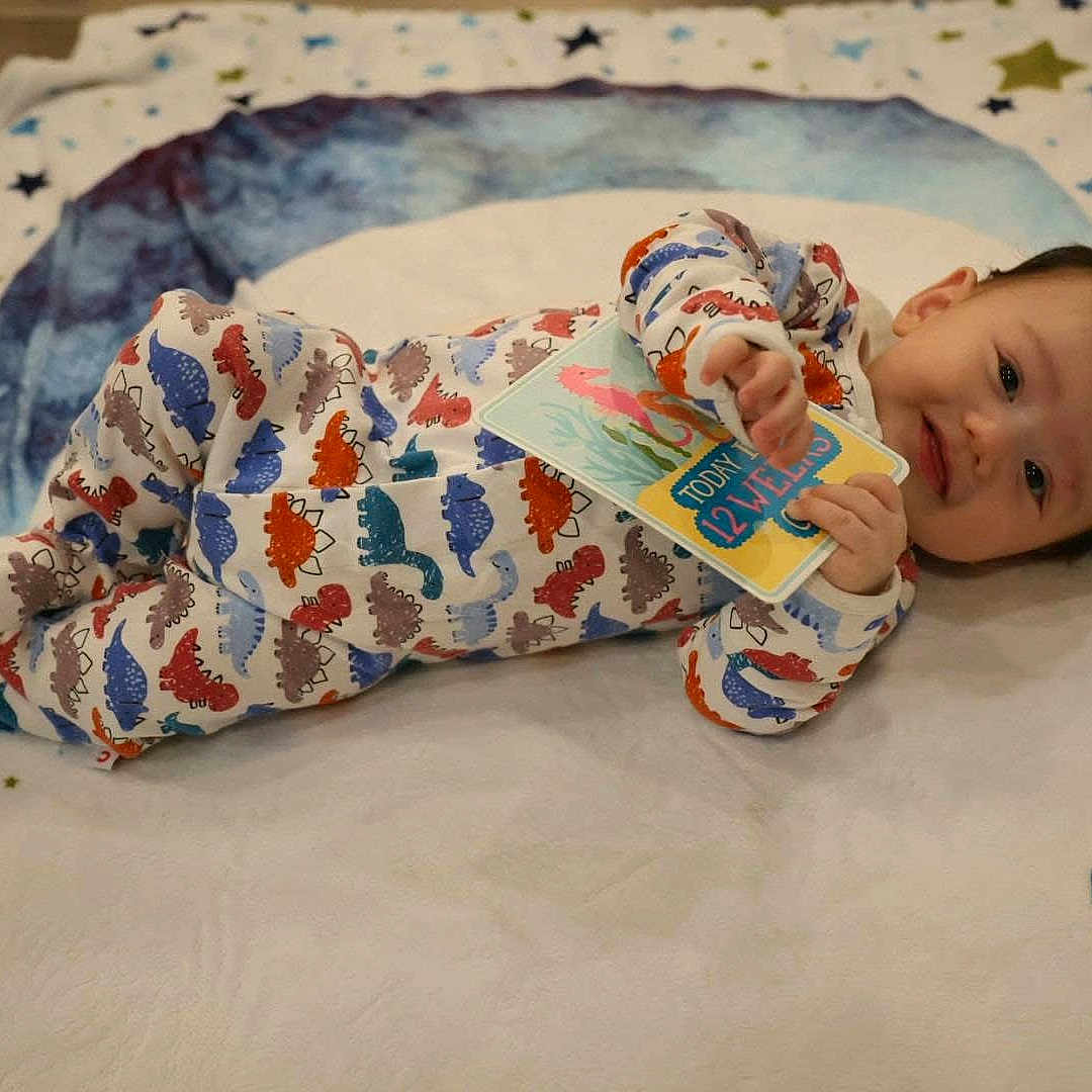Caden is registered to the contest to win money with this photo: advertisement, baby, blanket, businesscard, clothing, face, happy, head, newborn, pajamas, paper, person, photography, portrait, quilt, sleeping, sleeve, smile, tape, text