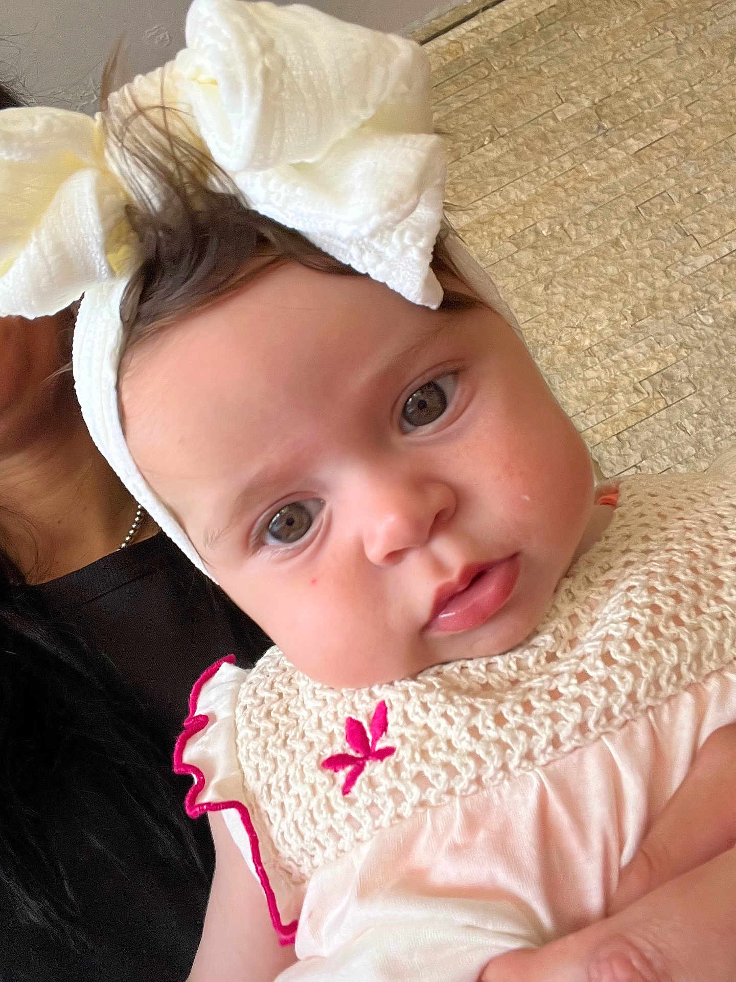 Diane a rejoint le concours — aidez-le/la à gagner de superbes lots ! baby, child, headband, bow, dress, knitted, pink, cream, face, eyes, person, closeup, portrait, cute, infant, hand, adult, background, wall, texture