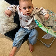 Rafaël a rejoint le concours — aidez-le/la à gagner de superbes lots ! baby_seat, barefoot, carpet, casual, child, clothing, curious, expression, furniture, home, indoor, jeans, light, person, pillow, portrait, reindeer, sweater, toddler, young_child