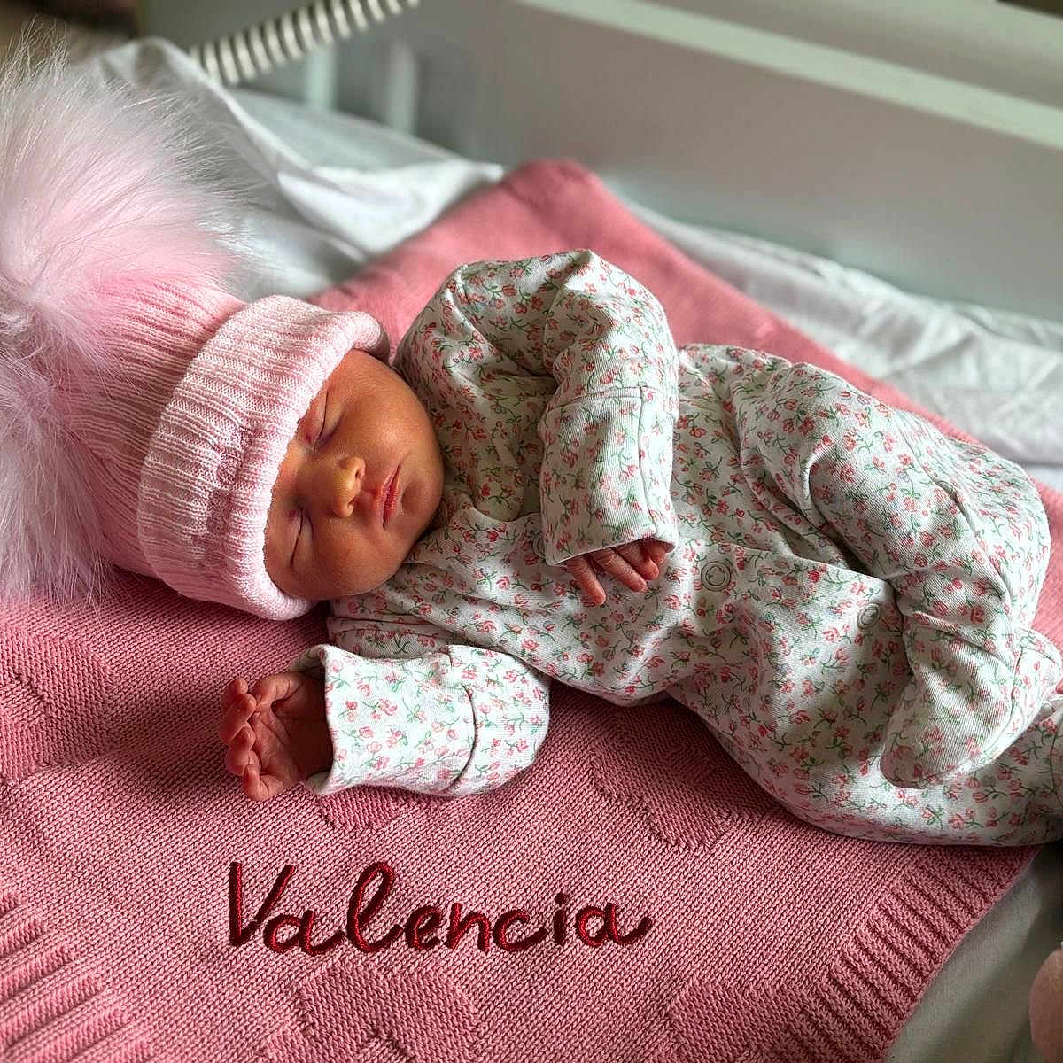 Valencia is registered to the contest to win money with this photo: baby, baby_bed, blanket, child, cozy, cute, floral_onesie, indoors, infant, knit_blanket, newborn, peaceful, pink_color, pink_hat, portrait, resting, sleep, sleeping, soft_texture, warm_clothing