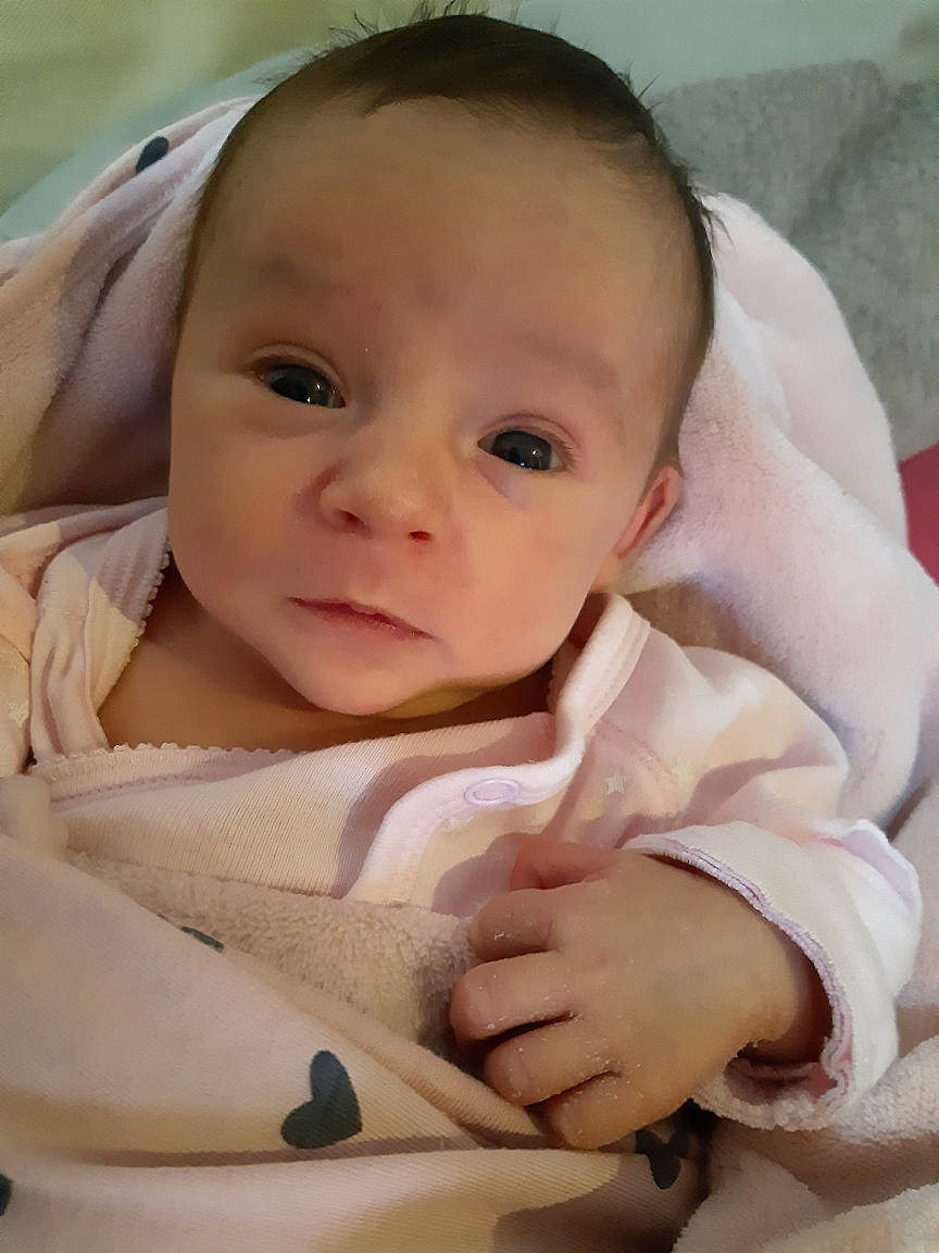 Liv participe au concours pour gagner de l'argent avec cette photo : baby, baby_products, baby_toddler_clothing, cheek, child, comfort, eyebrow, eyelash, happy, iris, linens, lip, nail, no_expression, nose, person, sitting, skin, smile, thumb