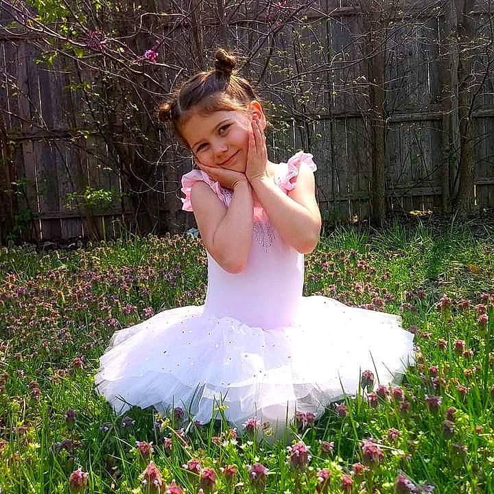 Aubrie is registered to the contest to win money with this photo: baby_toddler_clothing, bridal_accessory, dress, event, face, fence, flash_photography, flower, grass, happy, headpiece, joy, lawn, meadow, people_in_nature, person, petal, pink, plant, smile