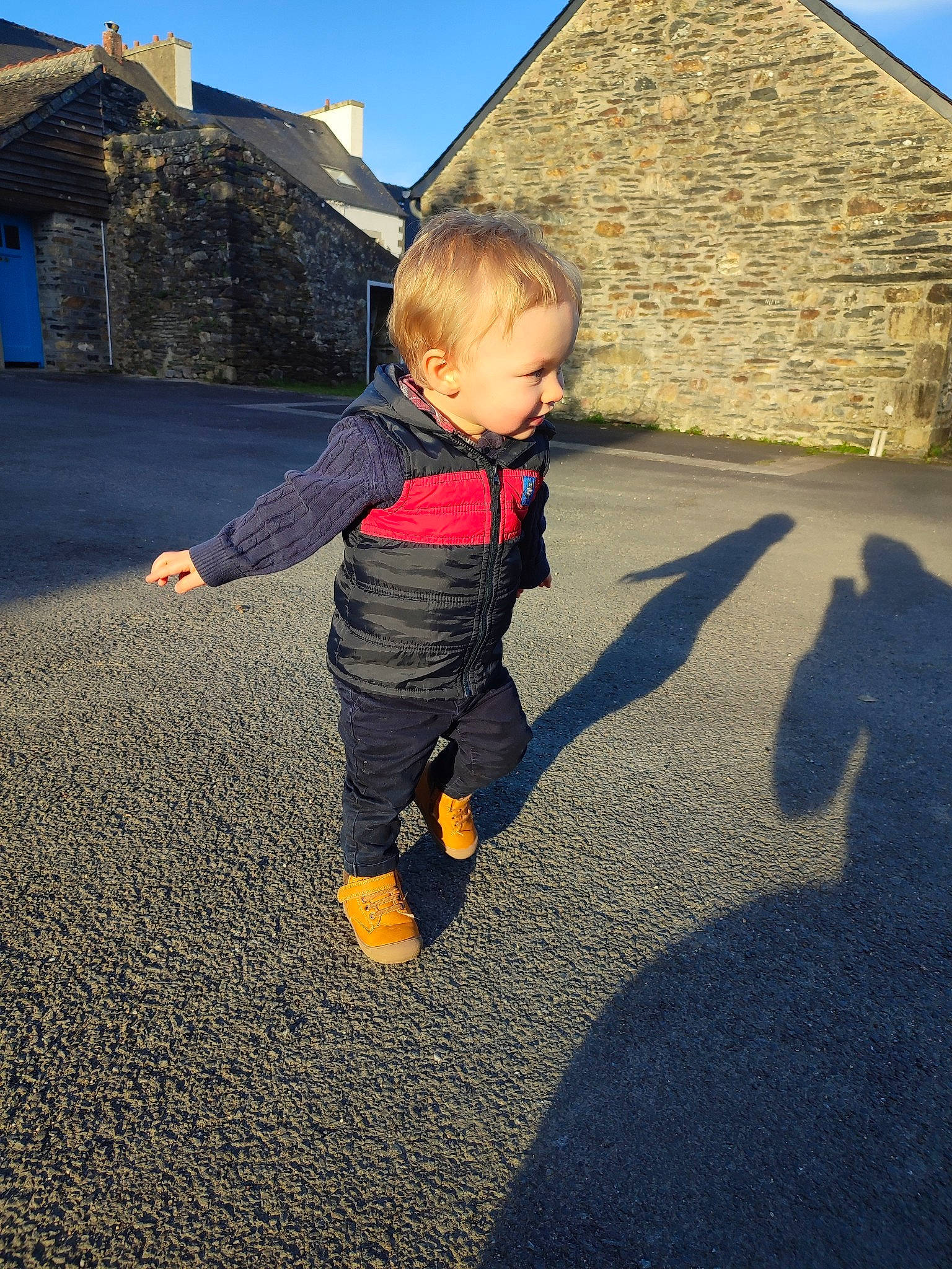 Hugo participe au concours pour gagner de l'argent avec cette photo : asphalt, baby_toddler_clothing, flooring, fun, grass, happy, house, human_body, landscape, leisure, people_in_nature, person, play, recreation, road_surface, shadow, sitting, sky, sleeve, tints_and_shades