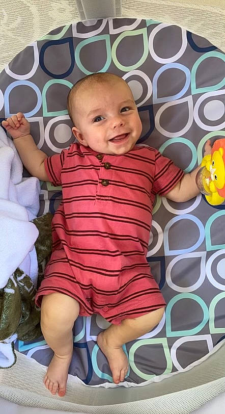 Rhett is registered to the contest to win money with this photo: baby, baby_toddler_clothing, cheek, eye, face, facial_expression, finger, fun, happy, head, joy, linens, nose, people, person, pink, product, skin, sleeve, smile