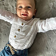 Nikodem is registered to the contest to win money with this photo: baby, child, smiling, white_shirt, blue_jeans, lying_down, happy, portrait, infant, cute, face, arms_outstretched, buttoned_shirt, denim, fabric, blanket, indoor, closeup, person, casual_clothing