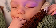 Coda is registered to the contest to win money with this photo: baby, sleeping, hand, blanket, knitted, cozy, face, peaceful, infant, portrait, closeup, child, soft_light, resting, cute, fingers, warm, indoor, head, relaxing
