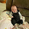 baby, infant, smile, headband, bow, overalls, shoes, blanket, couch, furniture, happy, child, indoors, cute, portrait, person, sitting, cozy, soft, home