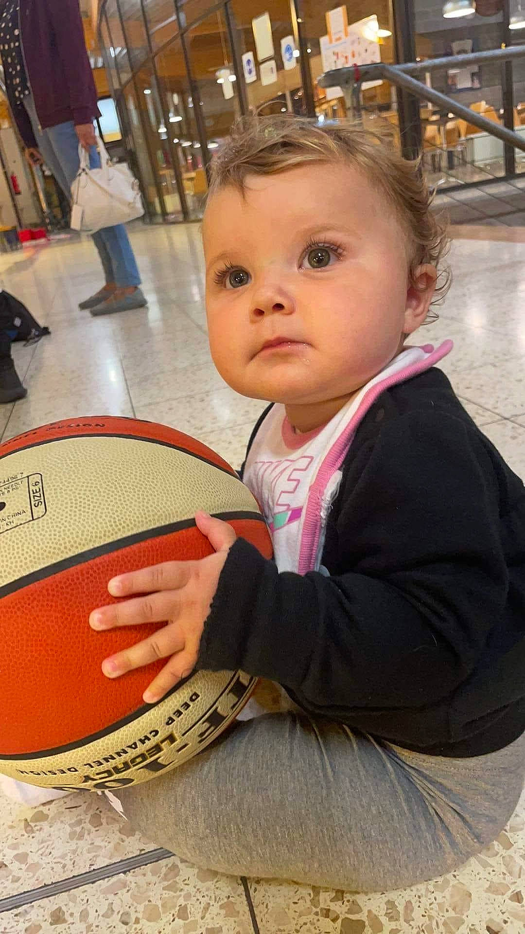 Xylia a rejoint le concours — aidez-le/la à gagner de superbes lots ! baby, baby_toddler_clothing, ball, blond, chair, cheek, child, clothing, eye, flooring, football, fun, head, nose, person, sitting, sports_equipment, standing, team_sport, toddler