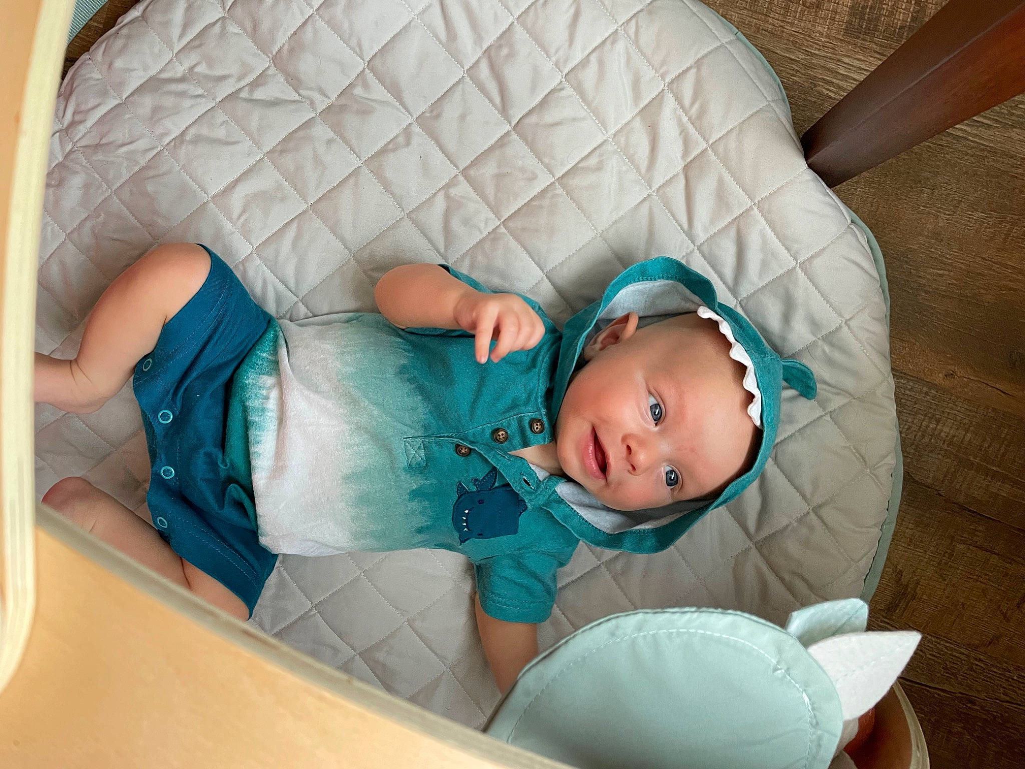 Travis is registered to the contest to win money with this photo: aqua, arm, baby, baby_products, baby_safety, baby_toddler_clothing, child, comfort, finger, hand, hat, headwear, human_body, leg, linens, pattern, person, product, room, sitting