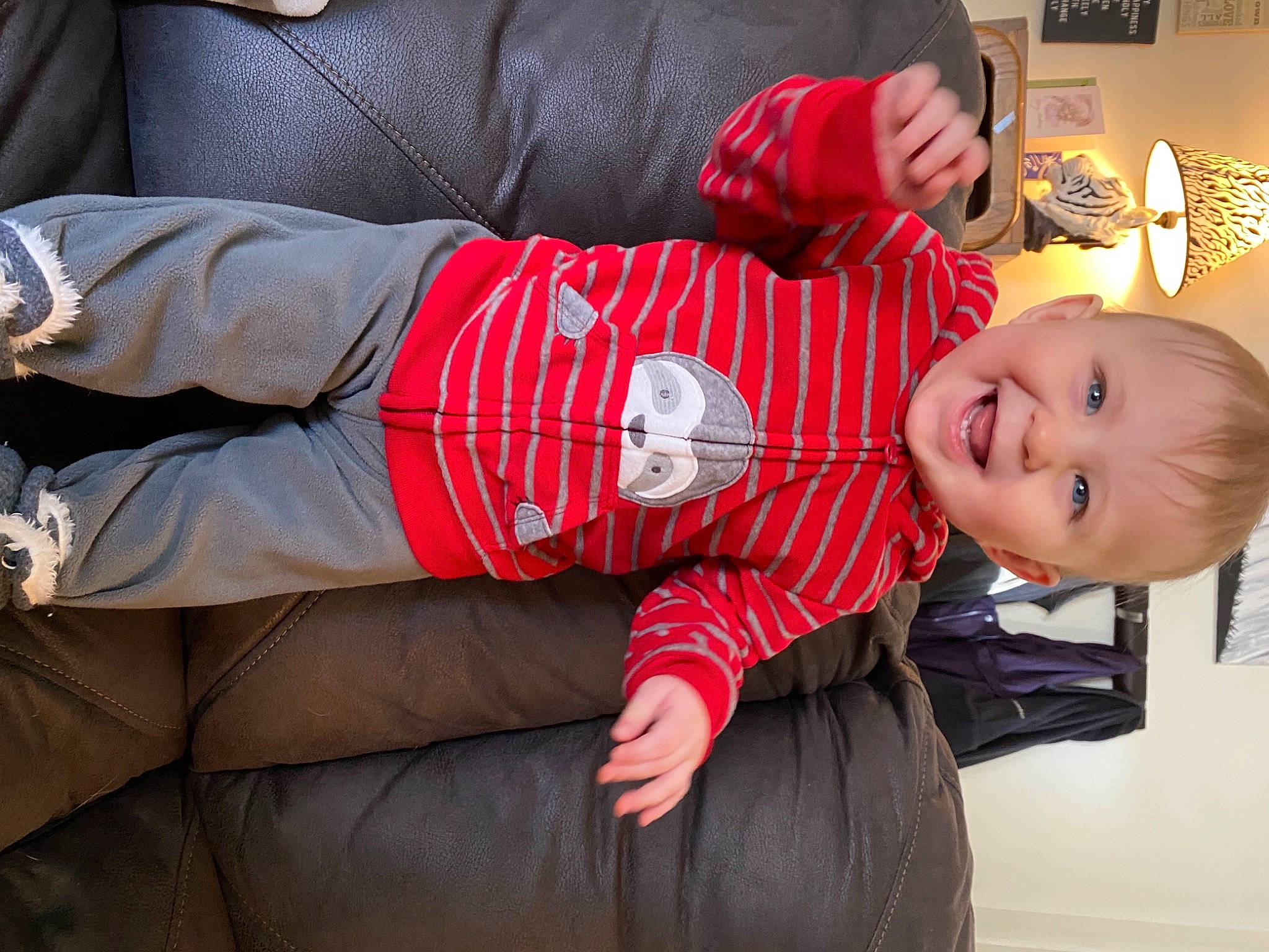 Declan is registered to the contest to win money with this photo: baby, baby_toddler_clothing, carmine, comfort, joy, lamp, lampshade, laugh, leather, lighting_accessory, person, picture_frame, red, sleeve, toddler