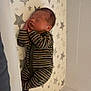 Arlo is registered to the contest to win money with this photo: baby, newborn, sleeping, crib, onesie, striped_clothing, star_pattern, mattress, mesh_crib_sides, infant, peaceful, resting, indoors, child, person, cute, cozy, baby_sleeping, nursery, soft_lighting