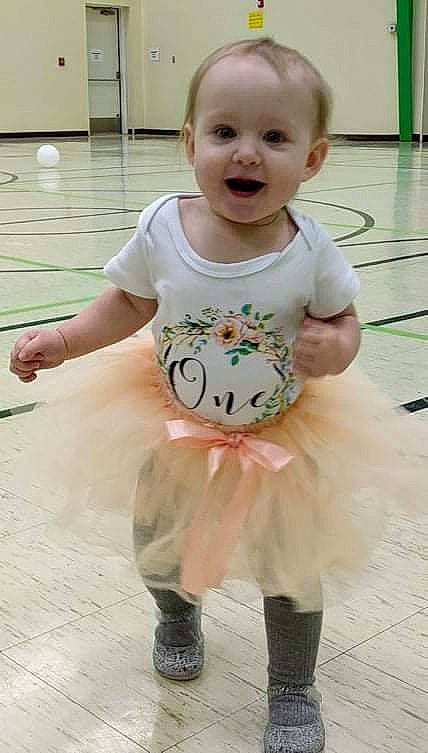 Daisy is registered to the contest to win money with this photo: baby, baby_toddler_clothing, beauty, child, dress, event, face, flooring, fun, green, happy, person, pink, sitting, skin, sleeve, smile, snapshot, standing, t_shirt