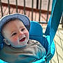 James joined the competition — help win amazing prizes! baby, blue, cheeks, child, clothing, cute, face, fun, happy, hat, headwear, infant, outdoor, person, porch, railing, seat, smiling, sunlight, swing