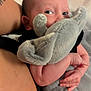 arm, baby, black_clothing, child, close_up, comfort, cozy, cuddle, elephant, eyes, face, fingers, hand, indoor, infant, plush_toy, skin, soft_texture, stuffed_animal, tattoo