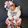Lucy is registered to the contest to win money with this photo: baby, blanket, bow, brown, child, couch, face, football, headband, indoors, infant, pink, portrait, sitting, smiling, sportswear, stuffed_toy, toy, white_clothing, wide_eyed