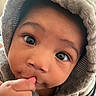 Amarjae is registered to the contest to win money with this photo: baby, child, face, hood, hand, thumb, curious, closeup, cute, infant, expression, warm_clothing, skin, portrait, eyes, person, indoor, soft_texture, cozy, adorable