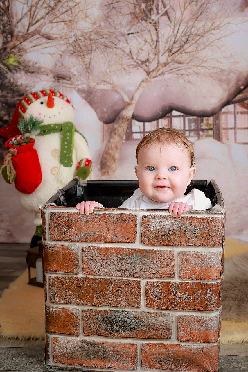 Freyja is registered to the contest to win money with this photo: baby, baby_toddler_clothing, brick, brickwork, cheek, child, event, eye, happy, home, joy, ornament, person, red, santa_claus, sitting, smile, toddler, tree, twig