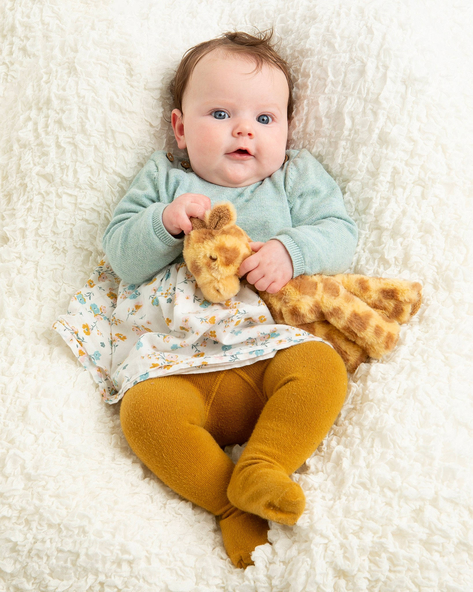 Freyja is registered to the contest to win money with this photo: arm, baby, baby_toddler_clothing, comfort, dress, eye, face, facial_expression, fawn, hairstyle, hand, head, human_body, knee, leg, person, skin, sleeve, textile, thigh