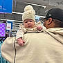 Ashanti Dafne joined the competition — help win amazing prizes! baby, child, adult, hat, pom_pom, glasses, cap, clothing, store, shopping, indoor, person, face, shoulder, hand, curious, calm, winter_wear, retail, hoodie
