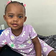 Taliyah joined the competition — help win amazing prizes! toddler, child, girl, purple_clothing, floral_pattern, hair_bows, bed, blanket, indoor, casual, smiling, cute, portrait, relaxed, young_child, person, skin, face, eyes, hair