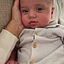 baby, blue_eyes, button, casual, closeup, clothing, comfort, couch, face, hand, indoor, infant, person, portrait, resting, sitting, skin, texture, warmth, young_child