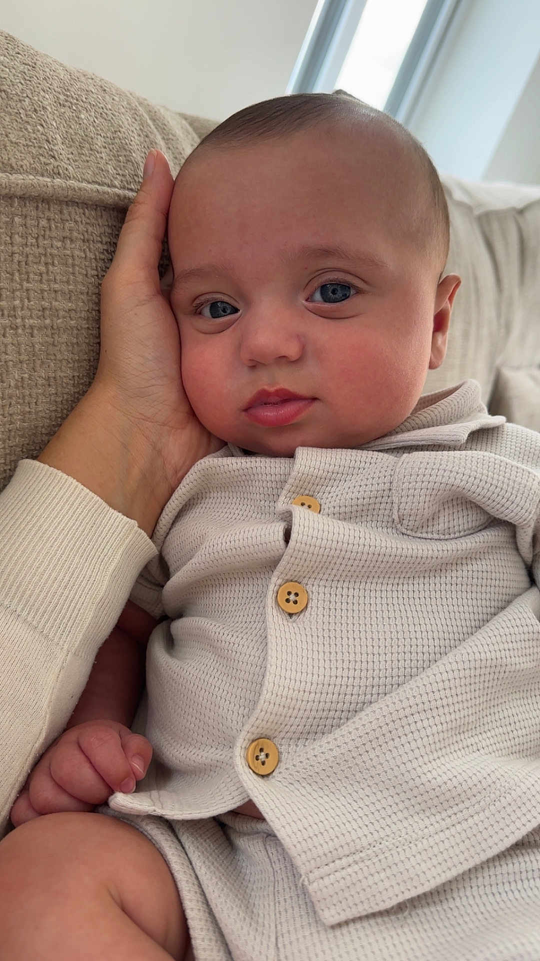 Isaac-George joined the competition — help win amazing prizes! baby, blue_eyes, button, casual, closeup, clothing, comfort, couch, face, hand, indoor, infant, person, portrait, resting, sitting, skin, texture, warmth, young_child