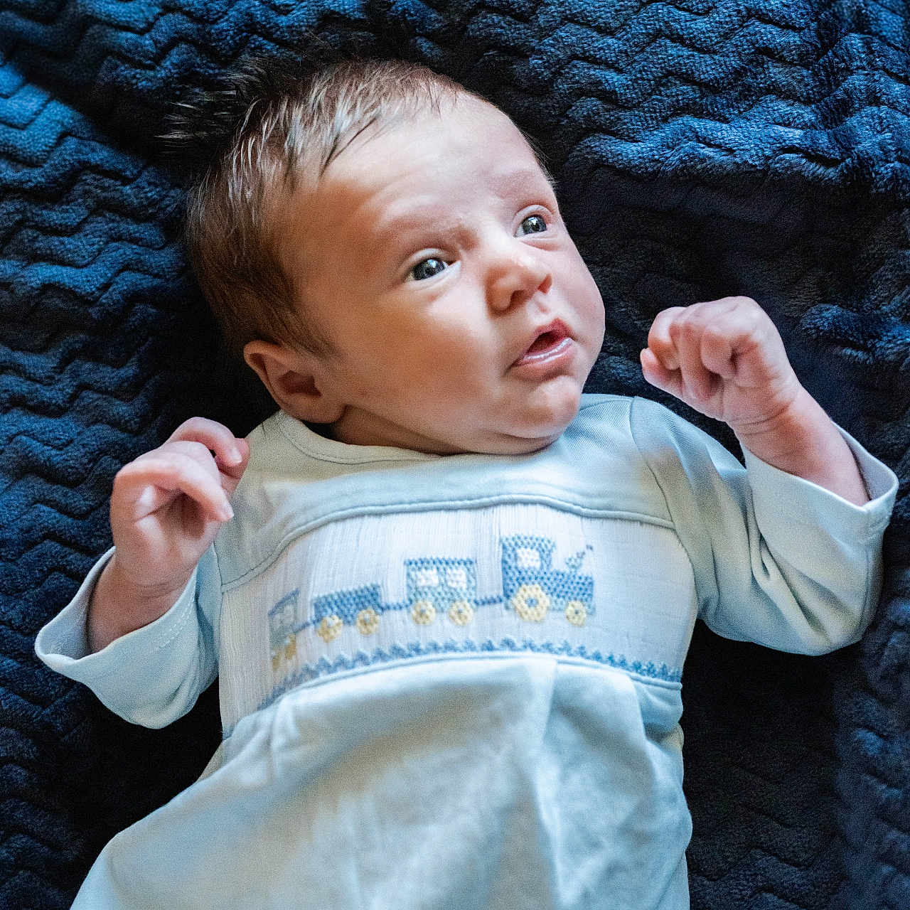 Sawyer joined the competition — help win amazing prizes! baby, bedding, blanket, blue_blanket, clothing, cozy, cute, eyes, face, gaze, hair, hands, infant, lying_down, newborn, nursery, onesie, portrait, soft_texture, surprised_expression