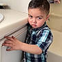 Xavier joined the competition — help win amazing prizes! child, boy, plaid_shirt, standing, bathroom, cabinet, sink, video_call, woman, hair_bun, indoor, serious_expression, hand, portrait, casual_clothing, light_skin, home, young_child, person, furniture