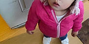 Debani is registered to the contest to win money with this photo: casual_clothing, child, cozy, curious, door, floor, indoor, knit_hat, looking_up, person, pink_hat, pink_jacket, pom_pom, shoes, standing, toddler, warm_clothing, white_door, wooden_floor, young_child