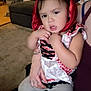adult_hand, carpet, child, clothing, costume, couch, expression, fabric, face, furniture, holding, home, indoor, person, portrait, red_hood, sitting, skin, tattoo, toddler