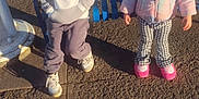 Debani is registered to the contest to win money with this photo: backpack, bench, casual, child, daytime, grass, hoodie, jacket, outdoor, pants, park, person, shadow, shoes, sidewalk, street, sunlight, two_children, winter_clothing, young