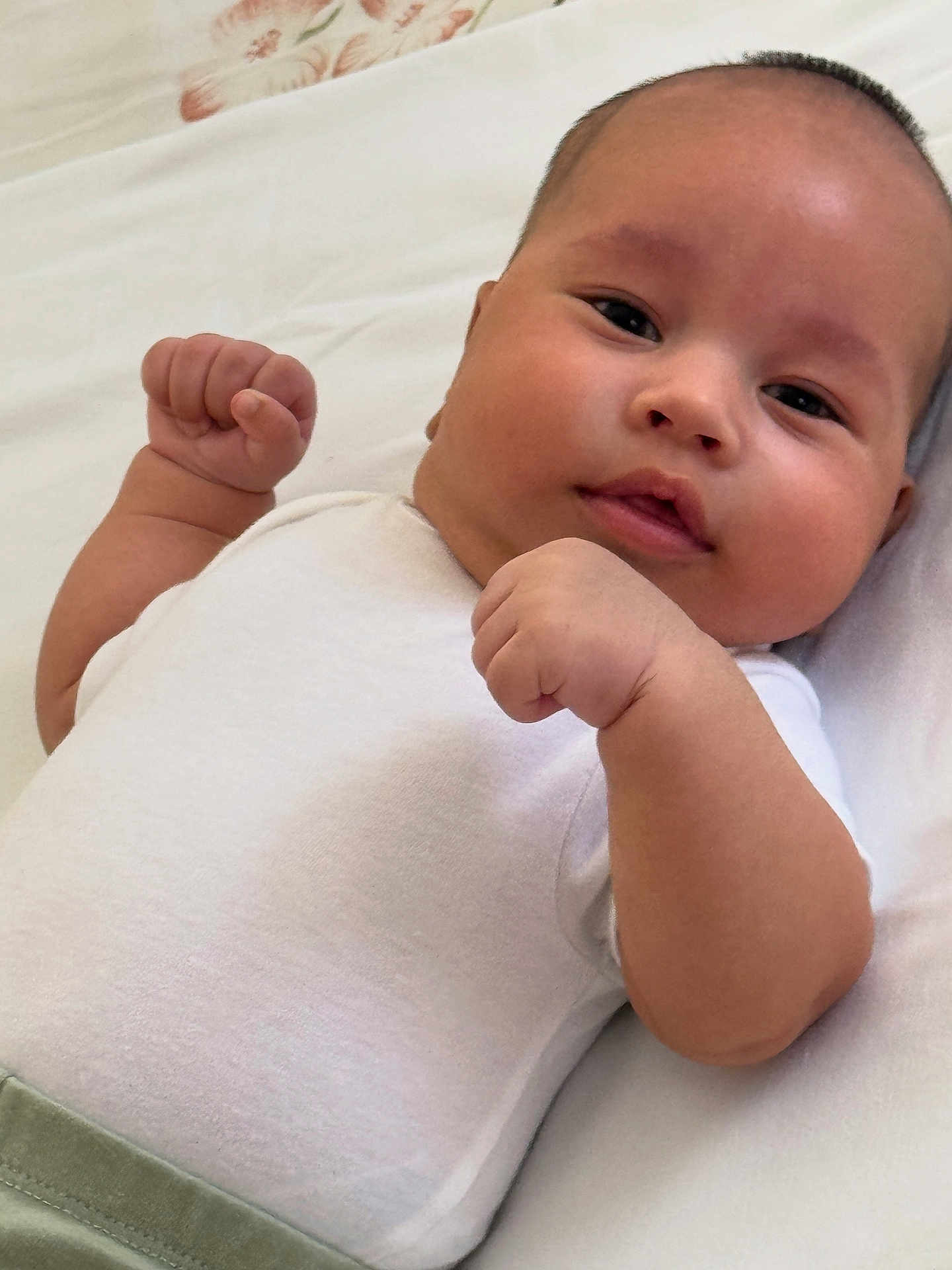 Abdullokhon is registered to the contest to win money with this photo: baby, infant, child, face, fists, white_clothing, lying_down, skin, cheeks, expression, person, cute, newborn, portrait, indoors, closeup, head, young, resting, soft_background