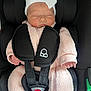 baby, infant, sleeping, car_seat, seatbelt, pink_clothing, white_bow, cute, child, newborn, soft_texture, bundle, safety, resting, face, headwear, small_hands, transportation, comfort, portrait