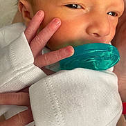 Lucas is registered to the contest to win money with this photo: newborn, baby, pacifier, hand, face, skin, closeup, infant, sleepy, white_clothing, fingers, tiny, soft, cute, newborn_baby, pacifier_teal, portrait, human, baby_clothes, peaceful