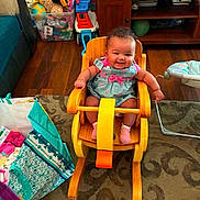 Montina joined the competition — help win amazing prizes! baby, carpet, child, colorful, curly_hair, floor, furniture, happy, indoor, living_room, pink_clothing, plastic_container, play, rocking_horse, seat, smiling, socks, storage_box, toy, wooden_chair