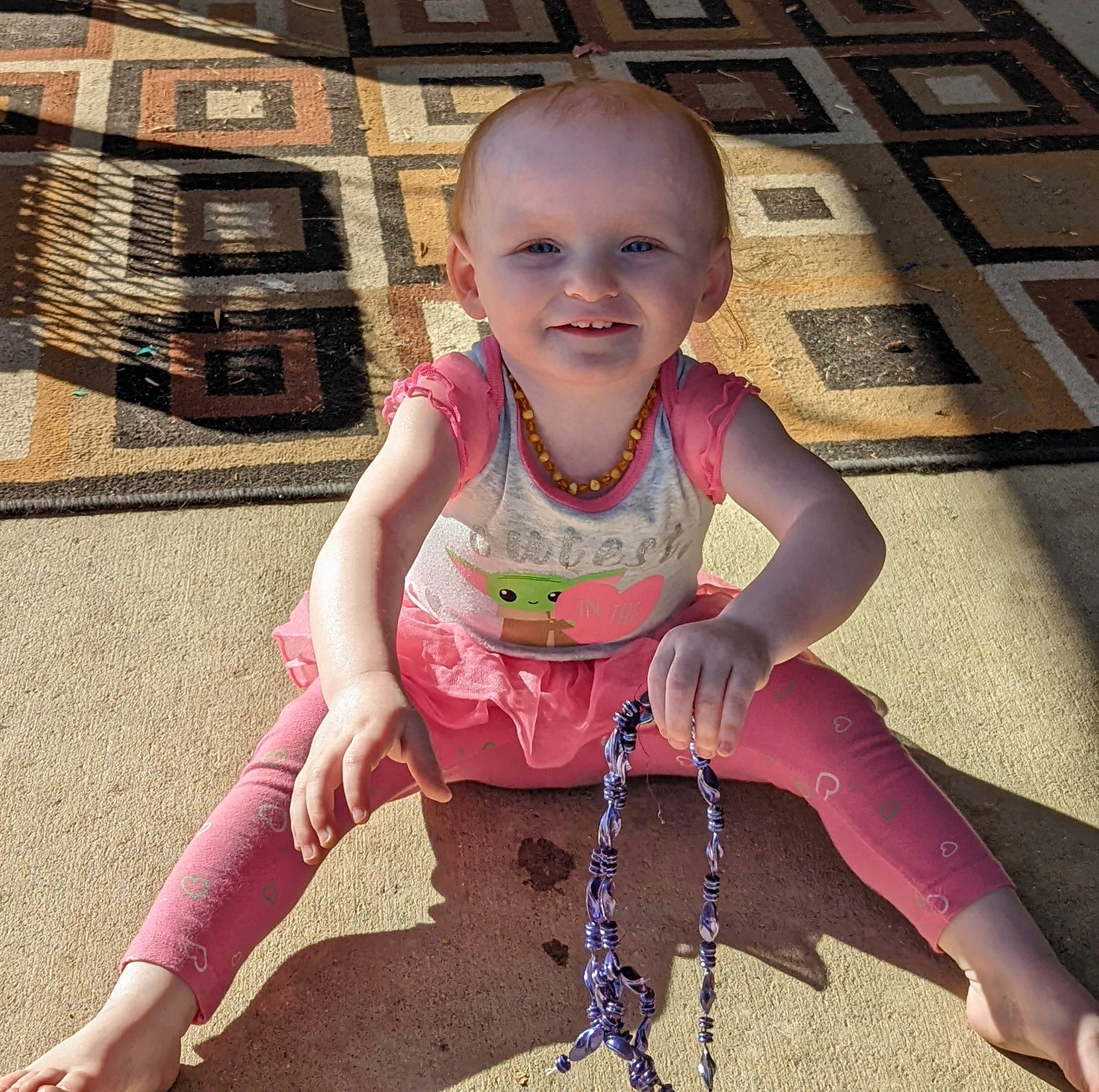 Emilia is registered to the contest to win money with this photo: baby, baby_toddler_clothing, child, cool, face, fun, grass, happy, head, human_leg, joy, leg, leisure, people_in_nature, person, pink, sitting, skin, smile, standing