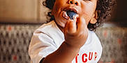 Noah is registered to the contest to win money with this photo: chickfila, child, closeup, cream, cup, curly_hair, cute, dessert, dining, eating, food, happy, indoor, messy_face, person, red_text, spoon, table, toddler, white_shirt