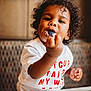 chickfila, child, closeup, cream, cup, curly_hair, cute, dessert, dining, eating, food, happy, indoor, messy_face, person, red_text, spoon, table, toddler, white_shirt