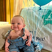 Romey joined the competition — help win amazing prizes! baby, balloon, blue_balloon, celebration, child, couch, cute, denim_overalls, face, happy, home, indoor, infant, milestone_blanket, person, portrait, sitting, six_months, smiling, string